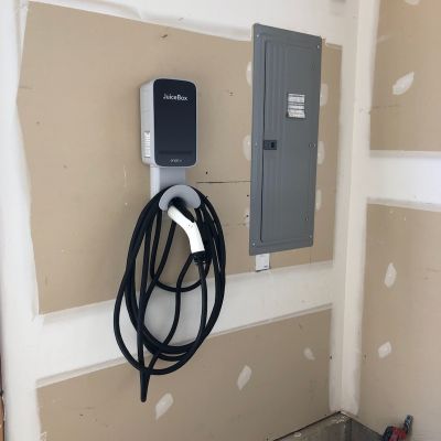 Electric Vehicle Charger Installed On Wall In Garage