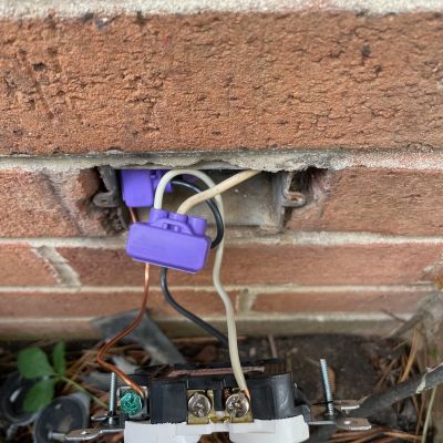 Exposed Wiring In Electrical Outlet On Brick Wall