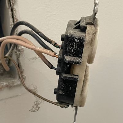 Damaged Electrical Outlet With Dust And Exposed Wires