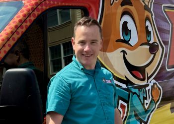Happy Man Next To Colorful Van With Cartoon Characters