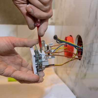 Installing Light Switch With Screwdriver And Electrical Wiring